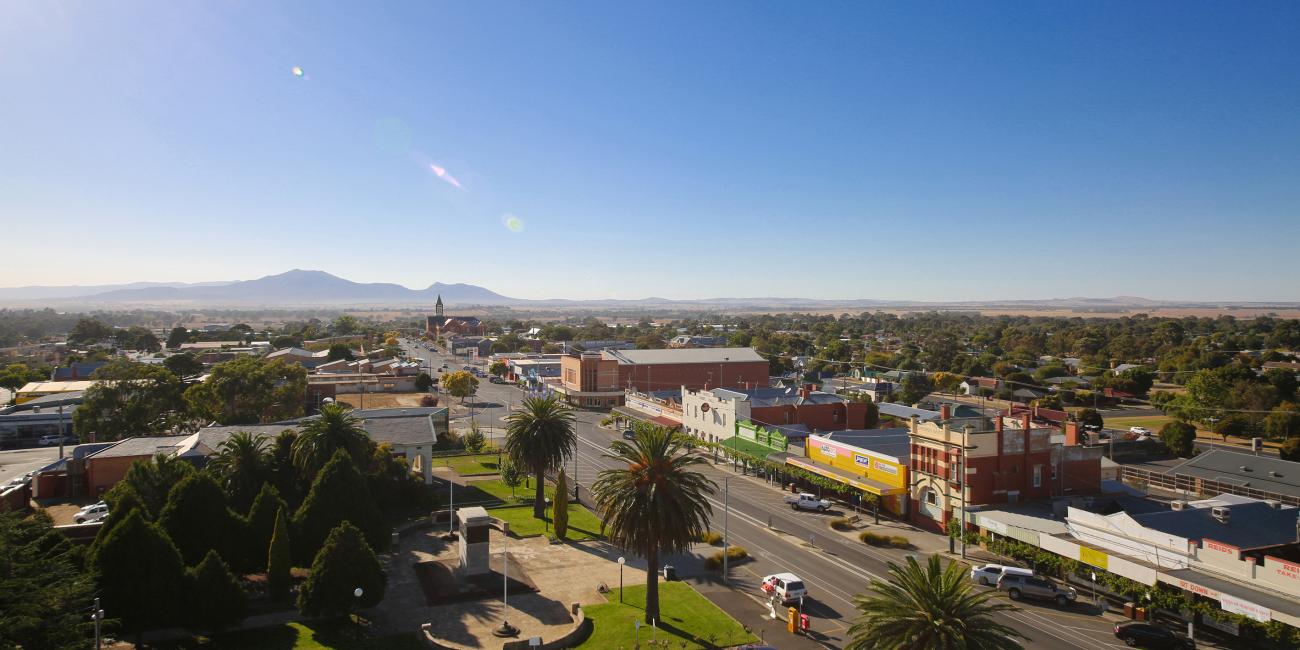 Long shot of a rural township on a sunny day with mountains in the background