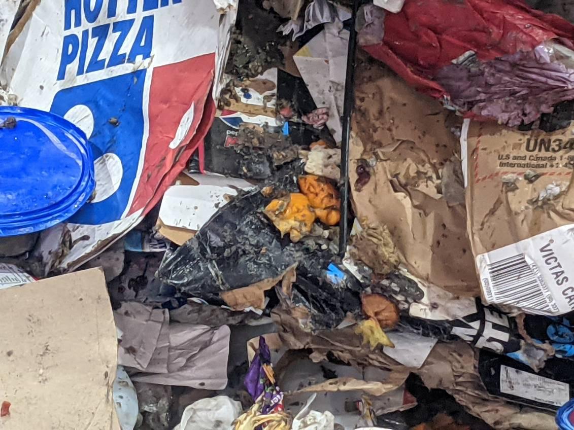 Pile of recycling material mixed with contaminants including bedding and other unrecyclable materials