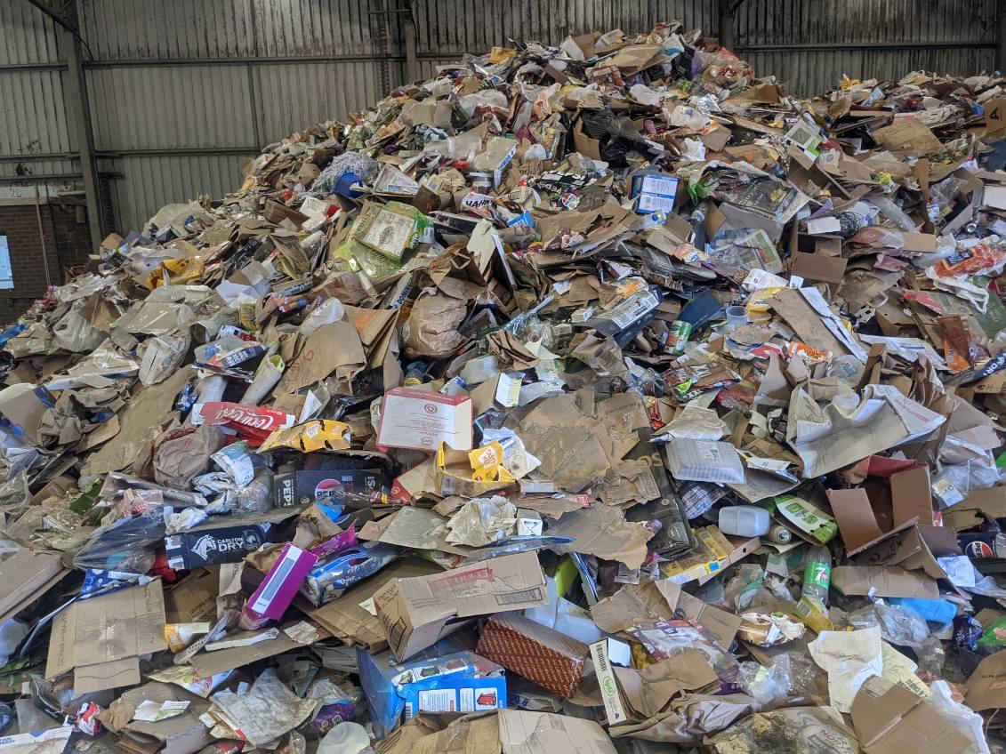 Large pile of clean recycling materials including cardboard and plastics