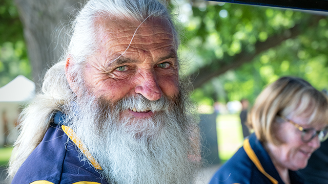 Man with white beard and Rotary Club uniform smiling into camera