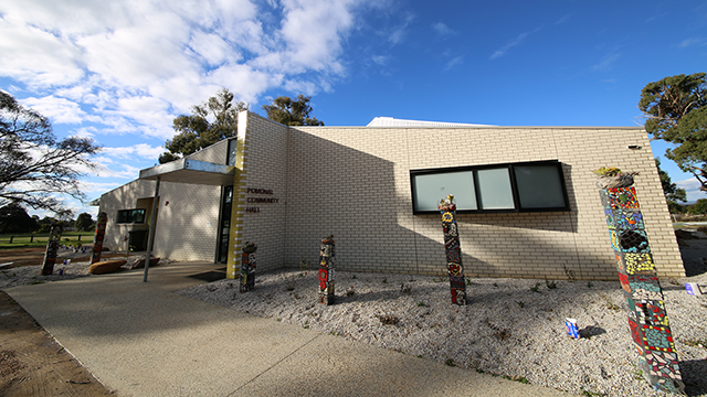 Regional Town Hall building with flowers and shrubs outside. The building's facade is white tiling